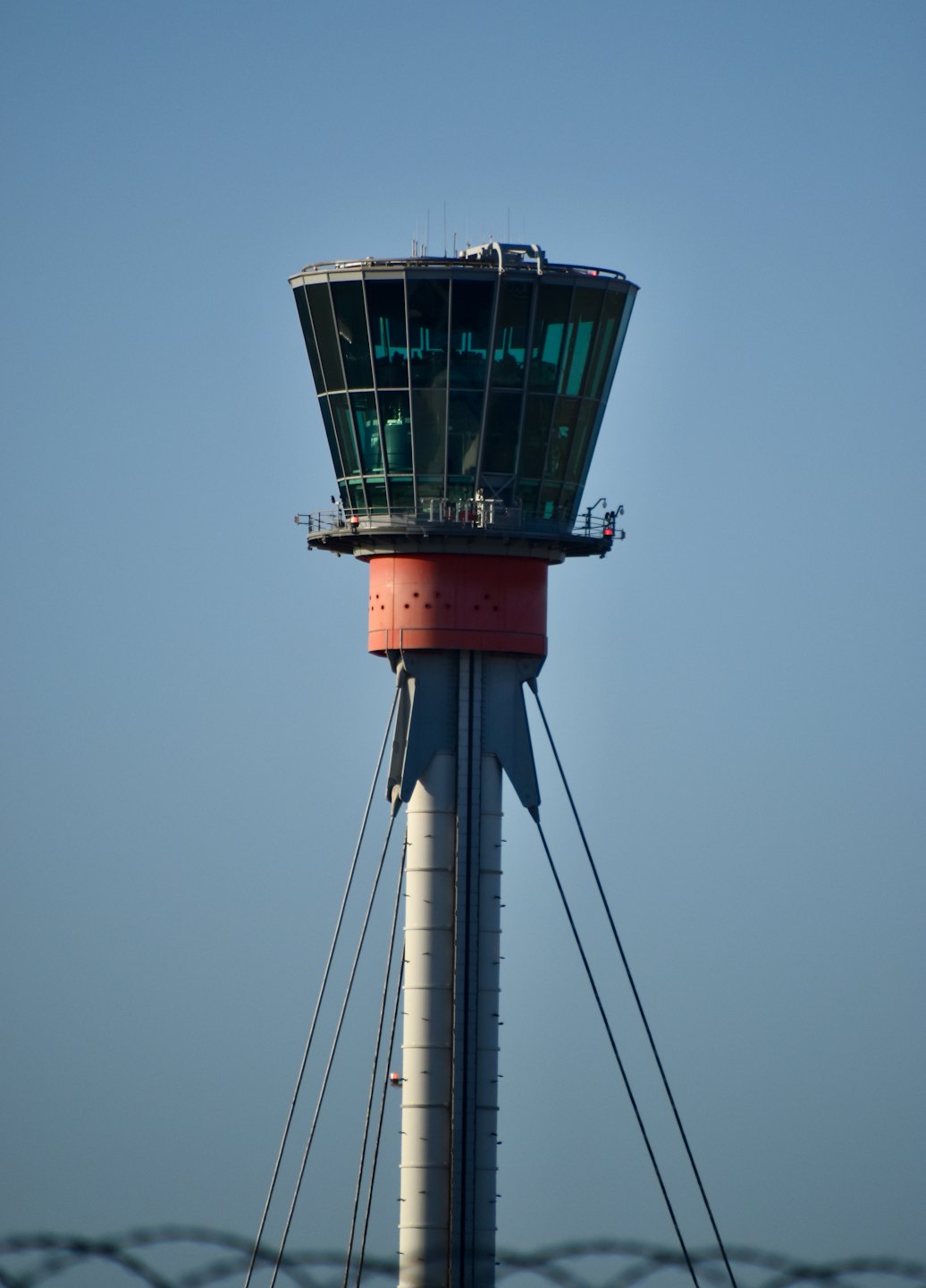Modern air traffic control tower reaches toward a clear sky.